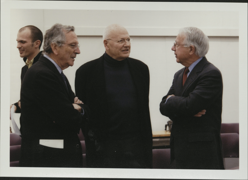 Rafael Moneo, Jorge Silvetti, and Gerald McCue engaging in a conversation while standing.