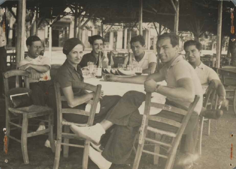 Participants sit around a table with some looking at the camera.