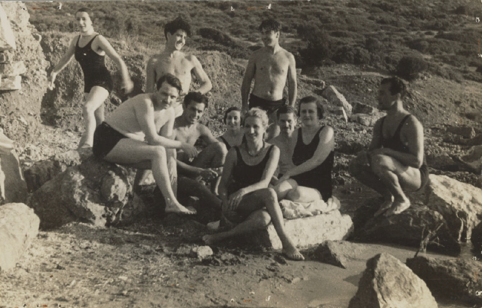 Participants in bathing suits at a waterfront.